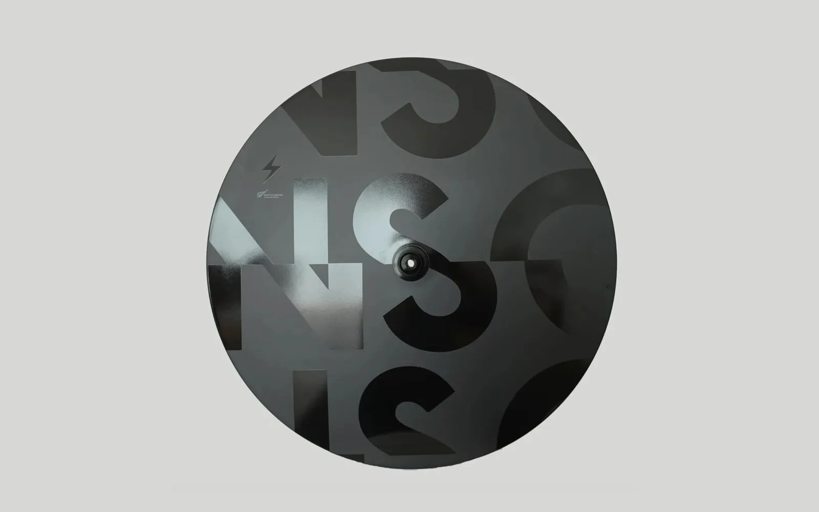 A Negative Split Carbon disc wheel with large overlapping NSC letterforms in gloss and matte black.