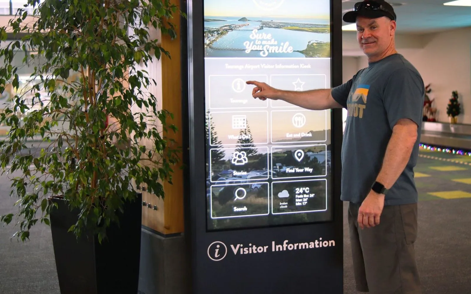 A visitor using the touchscreen visitor information kiosk at Tauranga Airport.