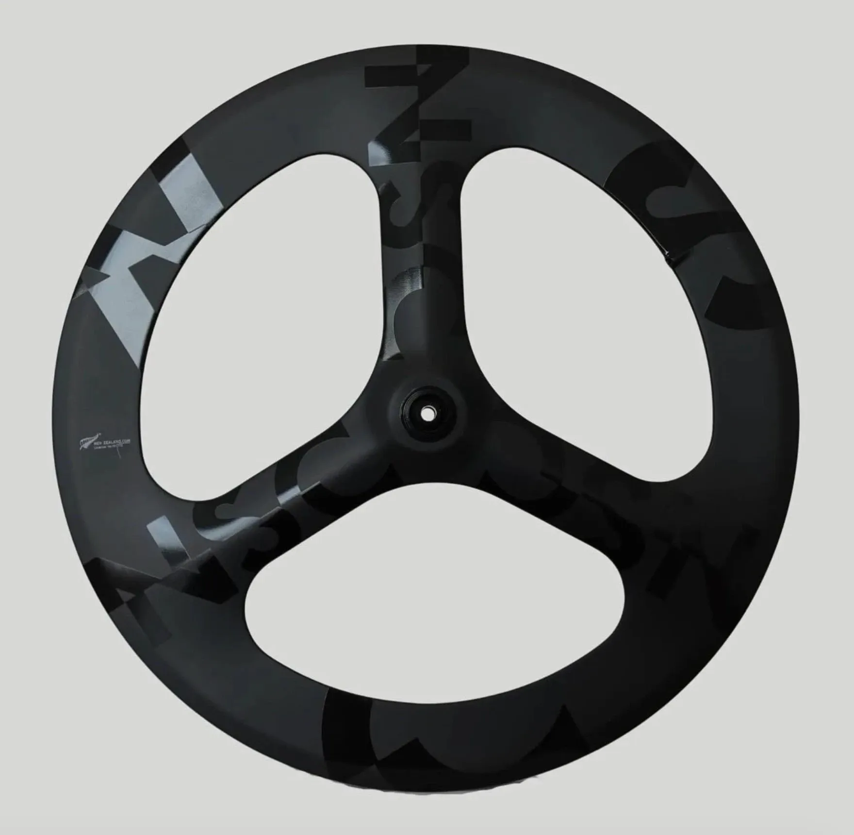A Negative Split Carbon tri-spoke wheel with letterforms wrapping the rim and spokes.