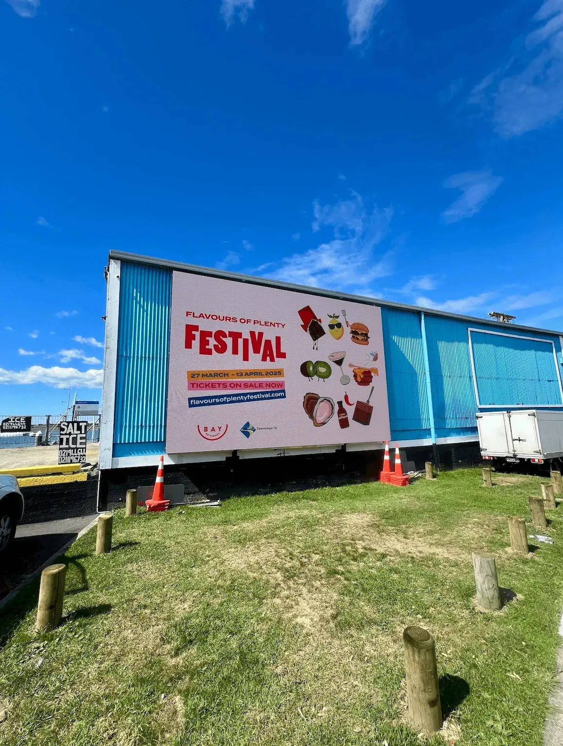 The festival campaign on a large outdoor billboard on a blue waterfront building.