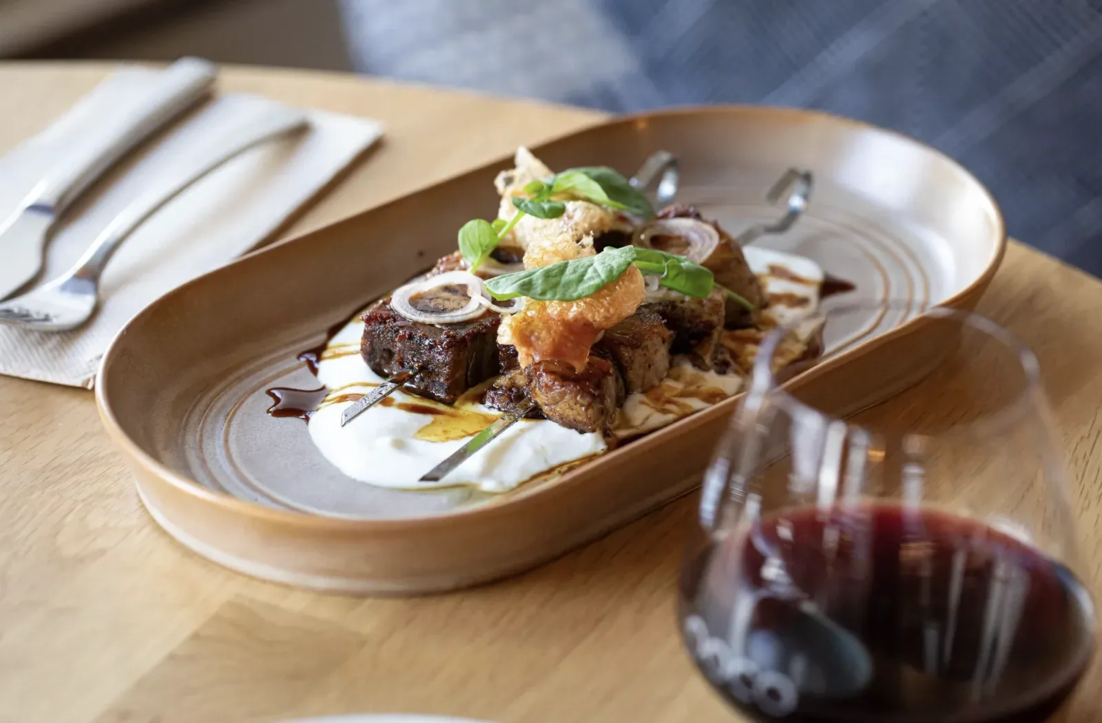 Chef-plated dish with a glass of red wine